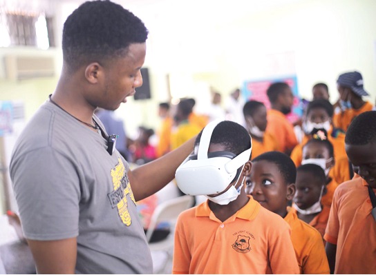 Jeffter Kobby Donkoh, Production and Chief Editor, Esports Africa News, giving one of the children a virtual reality (VR) experience.